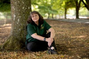 Liz, sitting by a tree
